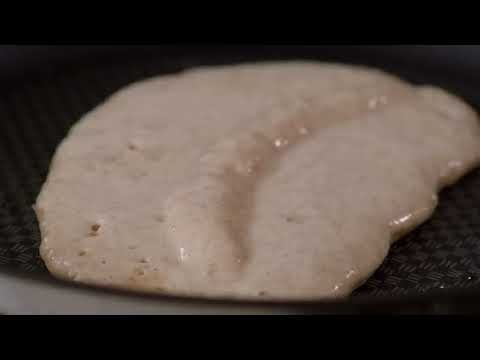 Pancakes moelleuses à la banane, accompagnées de yaourt, de miel et d'un mélange de fruits et de noix